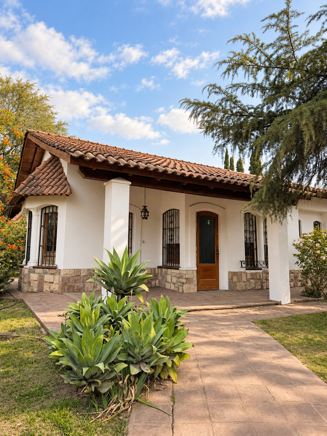 Frente de la casona de Artemisia, con galería, tejas y jardín